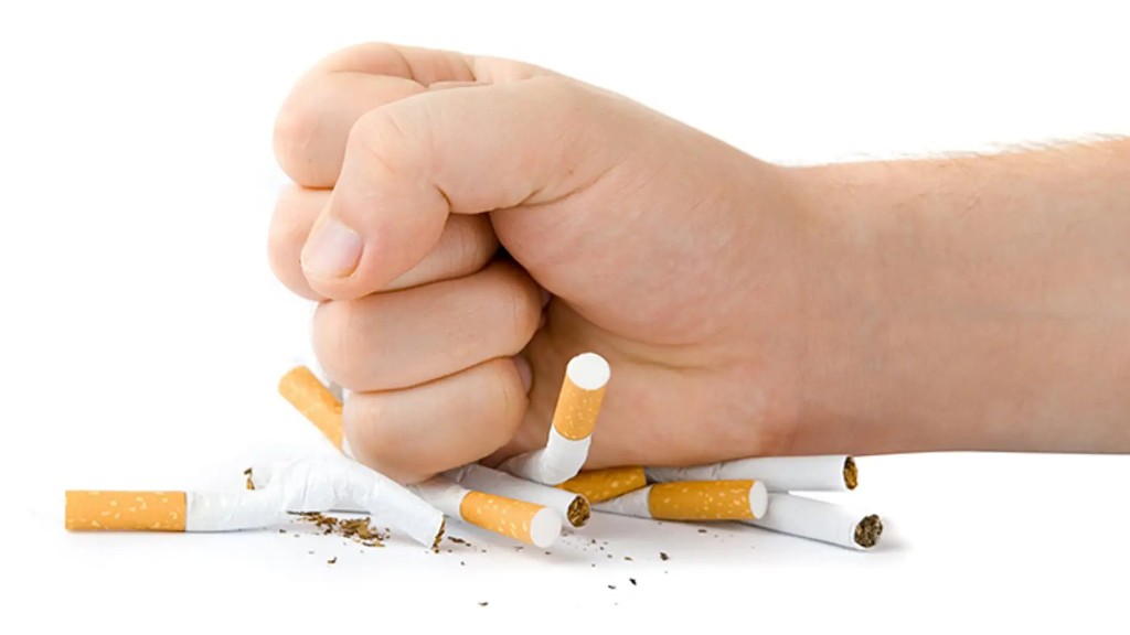 Puño aplastando cigarros